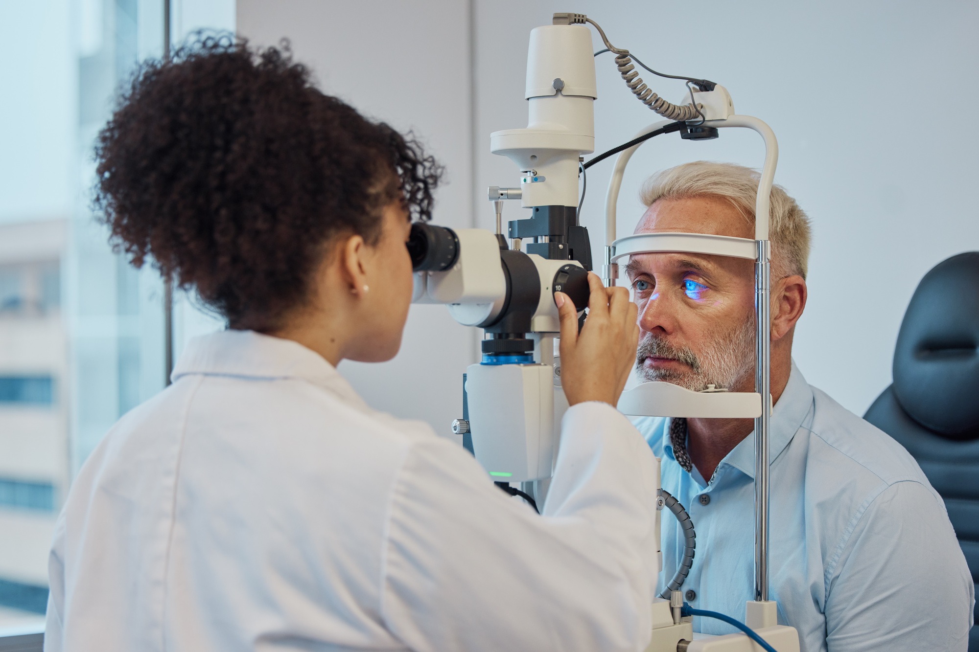 Vision, eye exam and healthcare with a doctor woman or optometrist testing the eyes of a man patien